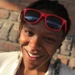 Headshot for Natasha Lane or Spark and Thrive Communications. She is smiling and wearing red sunglasses on her forehead.