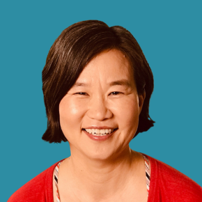Headshot of Katie Hong on an pond-colored background.