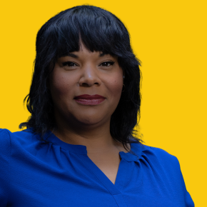 Headshot of Kristina Michele, looking at the camera with a slight smile, with shoulder-length black hair and bangs, wearing a bright blue blouse against a dandelion-yellow background.
