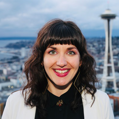 Headshot of Katie Carter smiling with the Seattle skyline and Space Needle in the background