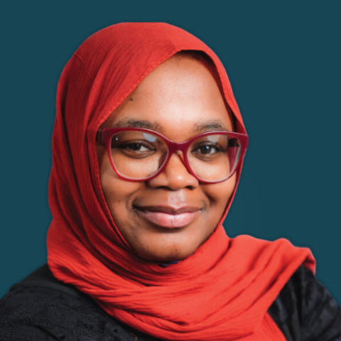 Headshot of Musu Bakoto Sawo, Director of Fundraising and Grants at the Community Foundation of Snohomish County, wearing a red hijab and glasses, smiling against a dark teal background.