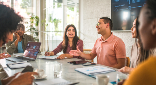 A dynamic and energetic team, comprised of ambitious individuals from various cultural backgrounds, engages in a lively discussion led by the project manager. This modern office setting exemplifies the power of cultural diversity.
