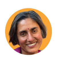 Headshot of Lalitha. Lalitha wears a pink top and has a small bindi on her forehead, posed against an orange circular graphic background.