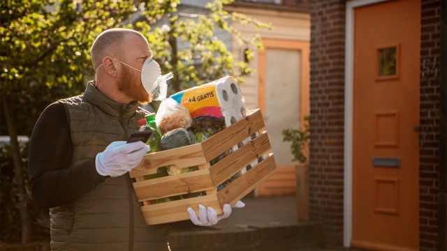 Man in a mask delivering food and groceries