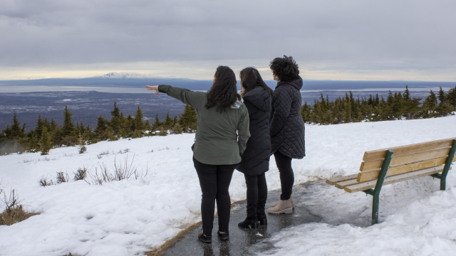 Photo of Philanthropy Northwest staff Mika (left), Jill (middle) and Nancy (right) in Anchorage, Alaska looking at scenery at a snowy mountaintop