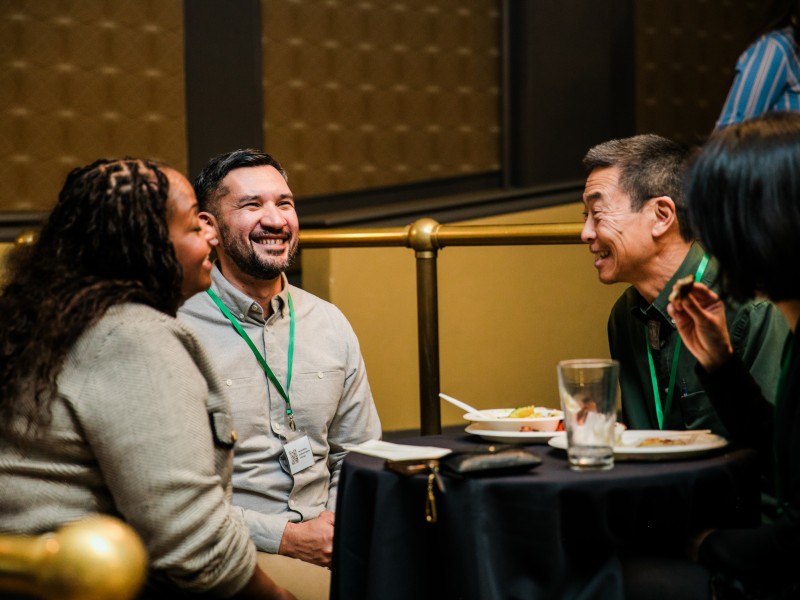 PNW24 conference attendees mingling and laughing at the welcome reception.