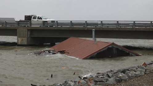 An image of a house submerged in typhoon waters up to its red roof.