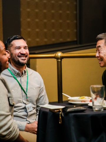 PNW24 conference attendees mingling and laughing at the welcome reception.