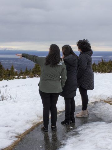 Photo of Philanthropy Northwest staff Mika (left), Jill (middle) and Nancy (right) in Anchorage, Alaska looking at scenery at a snowy mountaintop