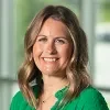 Headshot of Amy Gorn, Mat-Su Health Foundation, with a softly blurred background of large windows and greenery outside, suggesting an indoor setting with natural light.