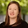 Jeri Rathbun headshot, program director at Waters Meet Foundation, smiling infront of a lush green background wearing a black shirt.